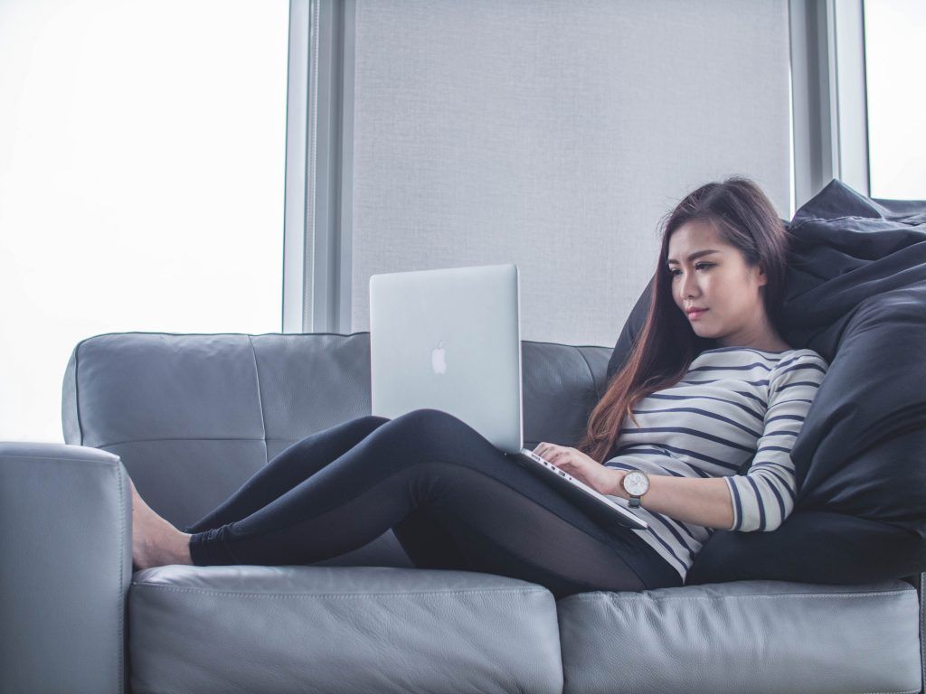 mujer sentada en el sofá mientras usa macbook pro FOTO: Unsplash